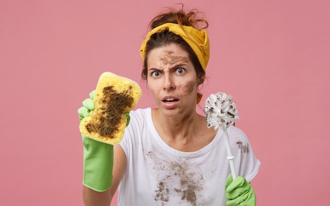 Driftig schoonmakende vrouw met vuile spons aan het schoonmaken