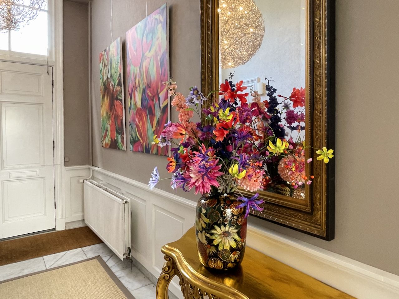 entree met tafeltje en grote bos kunstbloemen van fiori di rose in Oosterbeek